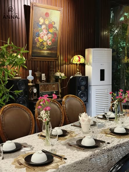 Bàn ăn được set up chỉn chu dưới bức tranh hoa tại Anna's Bistro