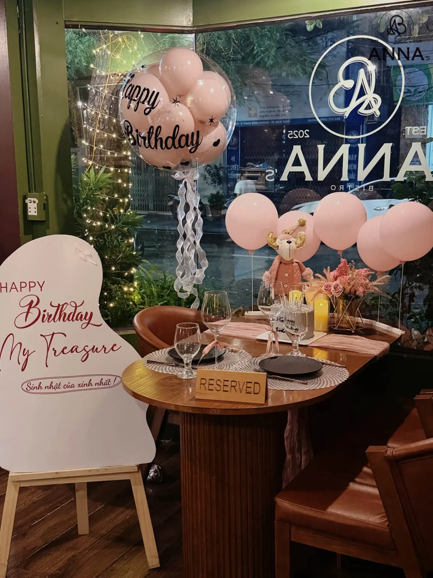 Bàn đã đặt trước cho tiệc sinh nhật tại Anna's Bistro với bảng chúc mừng và bóng bay