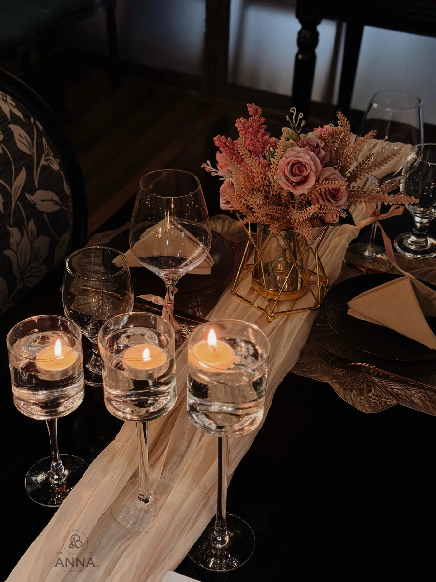 Nến và hoa trên bàn ăn tại Anna's Bistro
